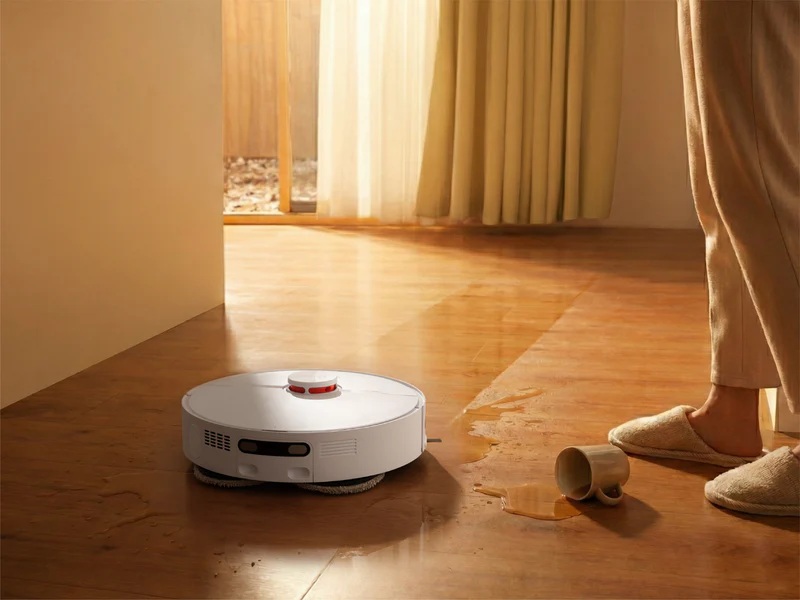 JONR T5 Pro Gen 2 usuwa z podłogi morką plamę powstałą przez wylanie płynu z kubka. Kubek leży obok robota