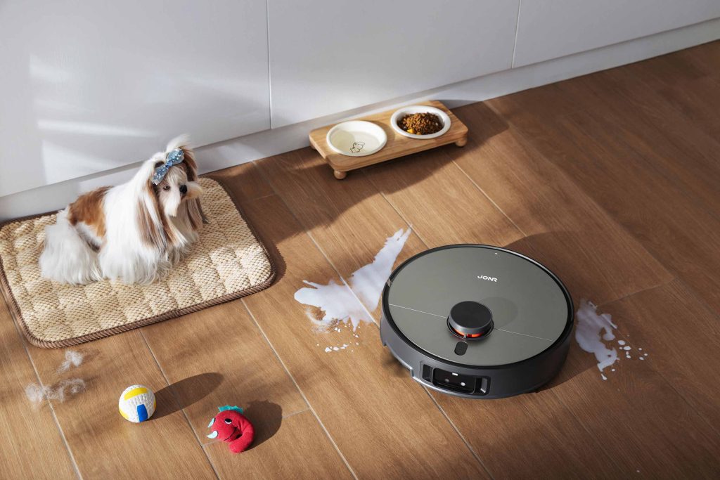 Personalizacja stref napędzana AI: robot JONR X9 Pro omija wirtualną strefę wokół dywanu z dzieckiem, obok telefon z mapą